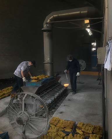 fundição de latão vazando em molde de castelo de areia de concha